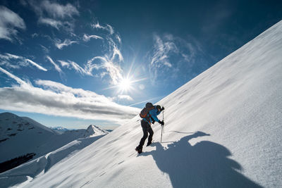 People skiing on snowcapped mountain against sky