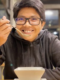 Smiling man holding soup in restaurant