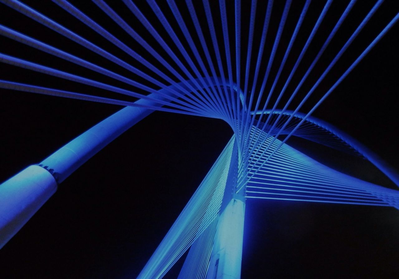 architecture, built structure, low angle view, blue, illuminated, night, modern, building exterior, connection, engineering, bridge - man made structure, clear sky, no people, transportation, diminishing perspective, sky, outdoors, tall - high, city, tower