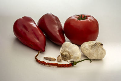 Close-up of red chili peppers on table against white background