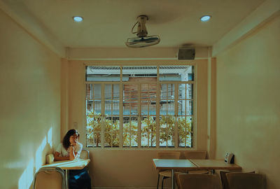 Young woman sitting on table at home