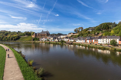 Scenic view of river by buildings against sky