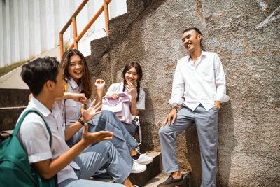 Friends standing against wall