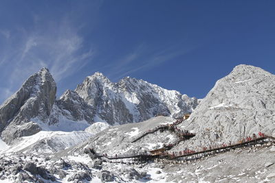 Scenic view of snowcapped mountains against blue sky