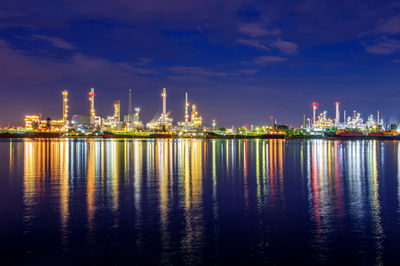 Illuminated factory against sky at night