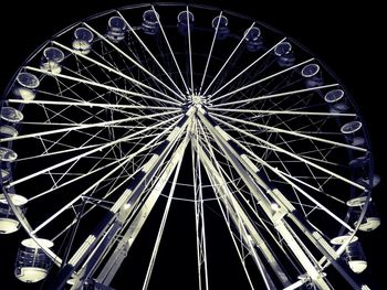 Low angle view of illuminated ferris wheel against sky at night