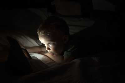 Portrait of boy lying on bed at home