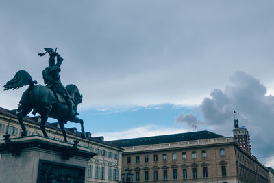 Low angle view of statue in piazza san carlo against cloudy sky