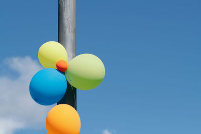 Low angle view of balloons against blue sky