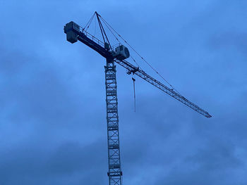 Low angle view of crane against sky