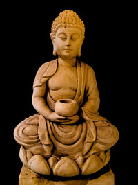 Low angle view of statue against black background
