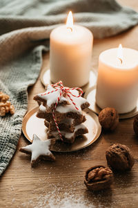 Close-up of lit candles on table with cookies