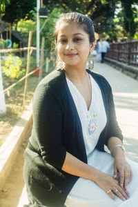 Portrait of smiling young woman sitting outdoors