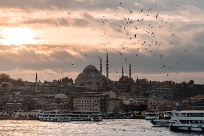 Panoramic view of buildings and city against sky during sunset