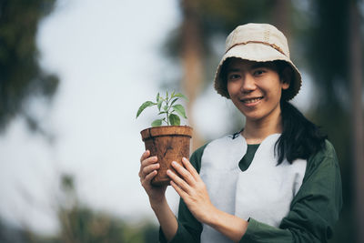 Portrait of smiling young woman holding food outdoors