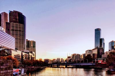 River by city buildings against sky