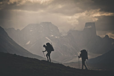 People on mountain range against sky