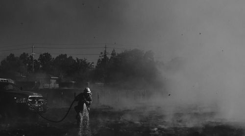 Rear view of man working at construction site during foggy weather