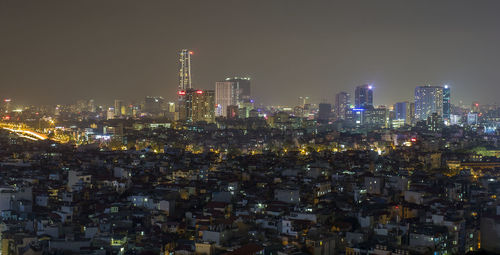 Illuminated cityscape against sky at night