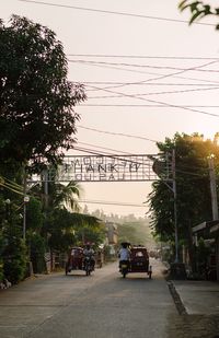 Cars on road in city against sky