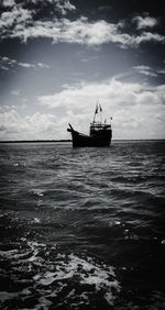 Silhouette sailboat in sea against sky