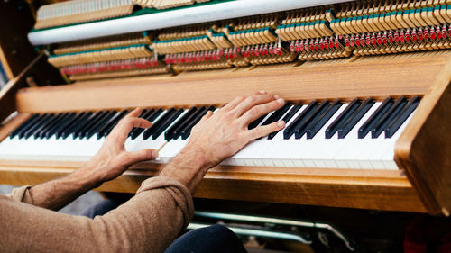 Cropped hands of man playing piano