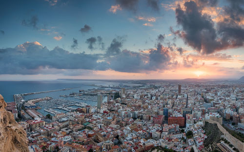 Aerial view of city against cloudy sky