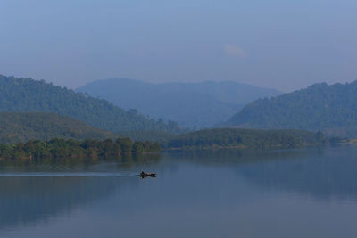 Scenic view of lake by mountains against sky