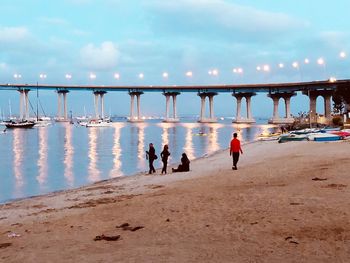 People at beach against sky