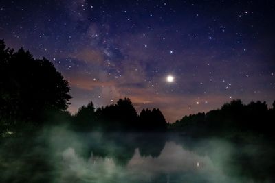 Scenic view of lake against sky at night