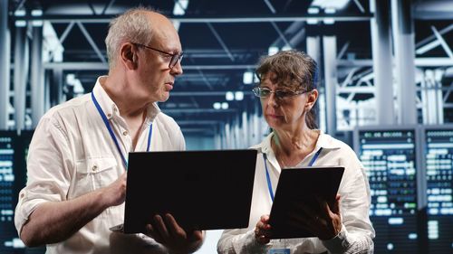 Side view of man using laptop while sitting at office
