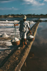 Man carrying salt in baskets 