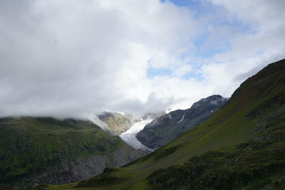 Scenic view of mountains against cloudy sky