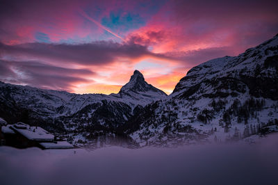 Scenic view of snowcapped mountains against sky during sunset