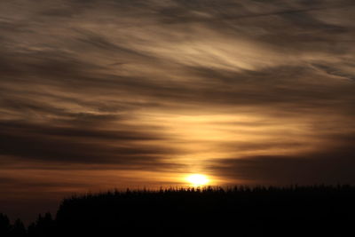 Scenic view of dramatic sky over silhouette landscape