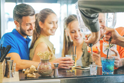 Close-up of bartender making drinks for people