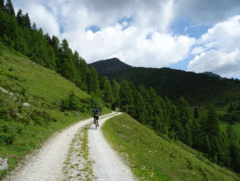 Man riding motorcycle on road against sky