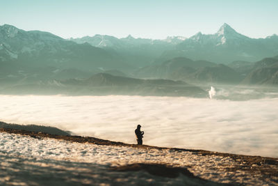 Man standing on shore against sky