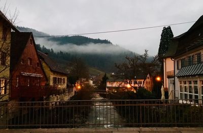 Illuminated buildings against sky during rainy season