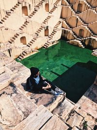 High angle view of woman sitting on built structure