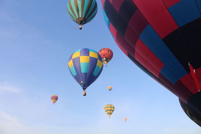 Low angle view of hot air balloons against blue sky