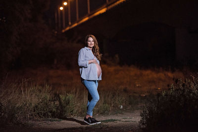 Full length portrait of woman standing at night