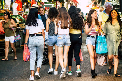 Group of people standing on zebra crossing in city