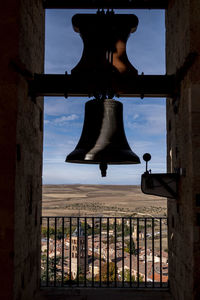 Low angle view of silhouette metal hanging on building against sky
