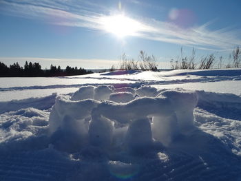 Snow covered field against bright sun