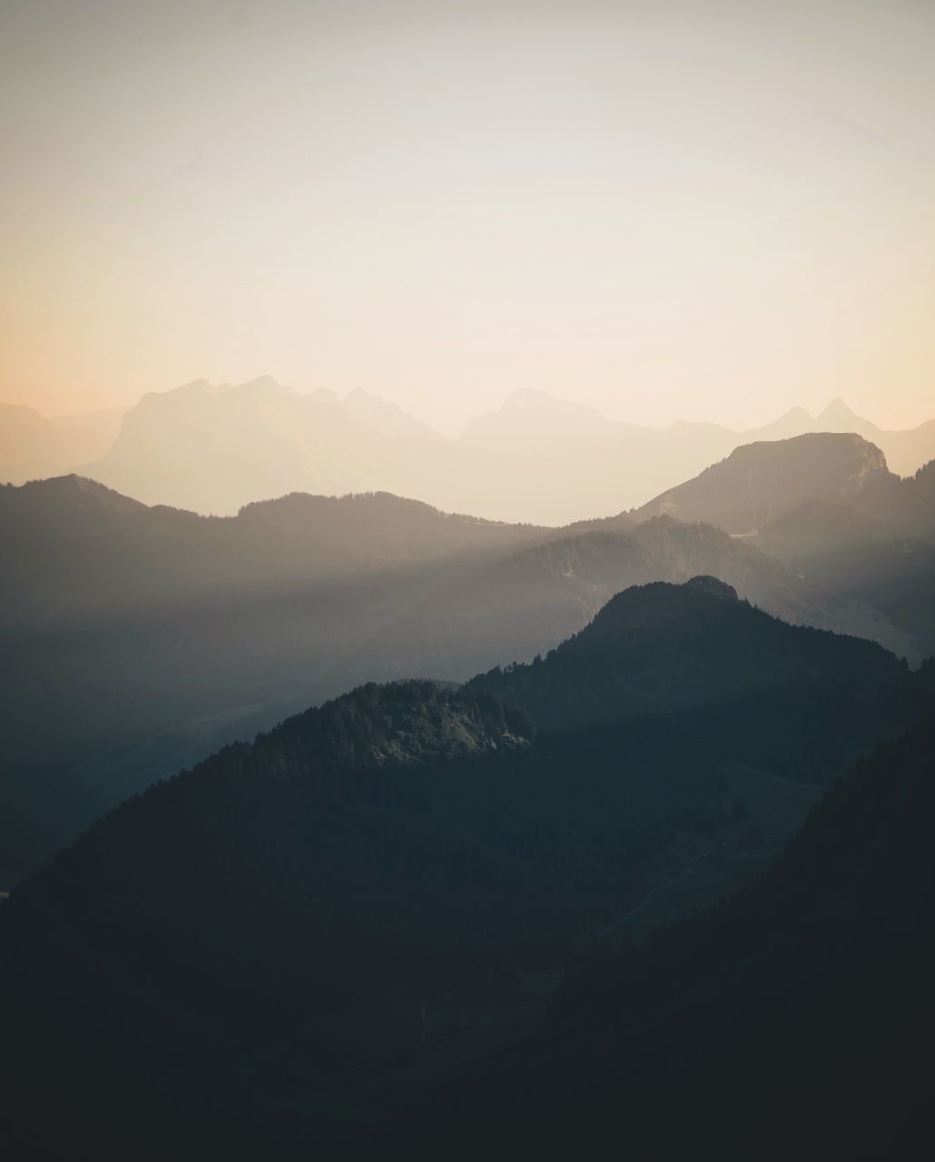 mountain, mountain range, tranquil scene, tranquility, scenics, beauty in nature, landscape, fog, nature, sunset, idyllic, sky, non-urban scene, outdoors, remote, no people, majestic, non urban scene, horizon over land, weather, dark