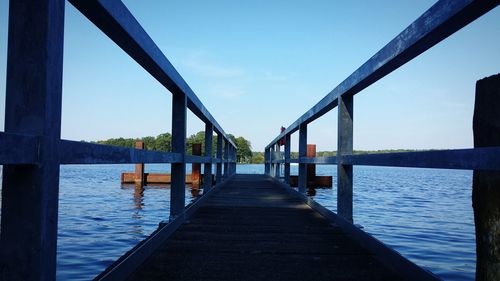 Pier on lake against clear sky