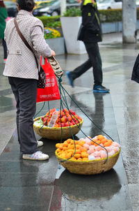 Rear view of man and fruits for sale at market stall