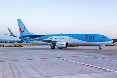 Airplane on airport runway against sky