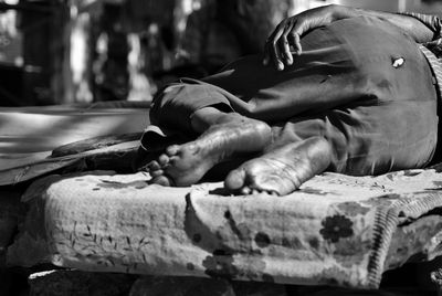 Low section of man lying on textile outdoors